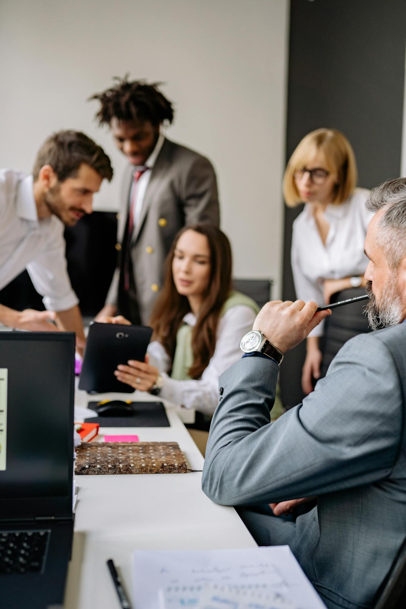 Group of professionals collaborating in a modern office, focusing on teamwork and diversity.